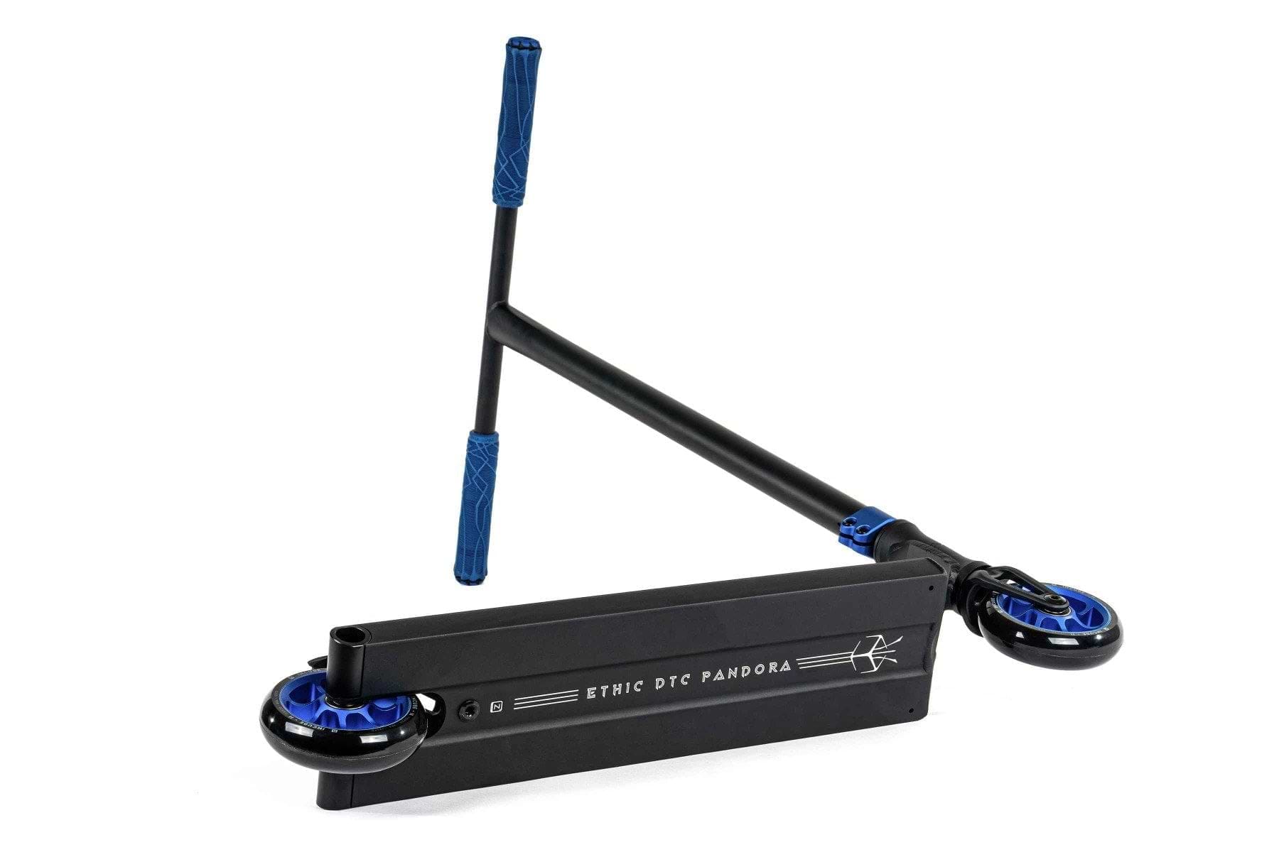 A black street-oriented scooter featuring a blue handlebar grip and blue wheels is displayed. The scooter has a slight tilt, showcasing the "Ethic DTC Pandora Complete Stunt Scooter (M) - Blue" branding on the deck, along with its sturdy chromoly steel T-bar.