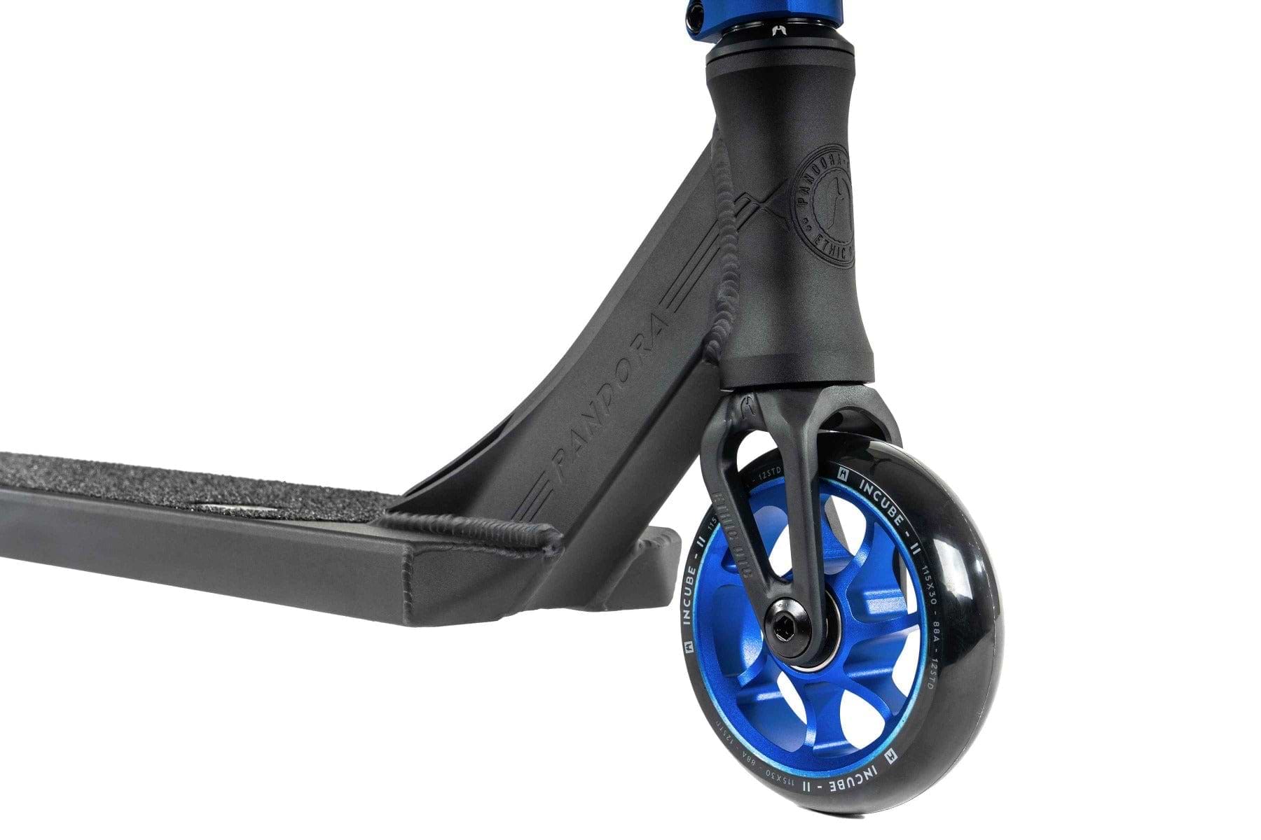 A close-up of a blue and black scooter, the Ethic DTC Pandora Complete Stunt Scooter (L) - Blue, highlighting the front wheel and deck. The wheel is blue with black rubber, while the textured deck provides excellent grip. It features a chromoly steel T-bar for added durability and has embossed branding details from Ethic, emphasizing its street-oriented design.