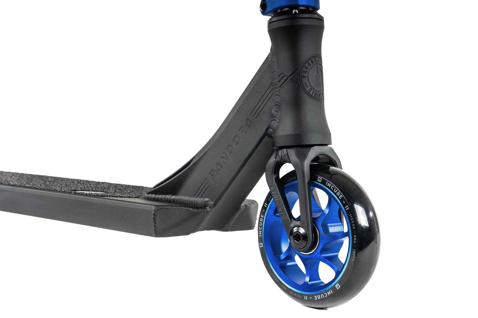 Close-up of the Ethic DTC Pandora Complete Stunt Scooter (M) - Blue, highlighting the front wheel with its black tire and blue metal rim. The black deck boasts a textured grip surface, while showcasing the fork and headtube area. This street-oriented scooter by Ethic features a durable chromoly steel T-bar for optimal performance.