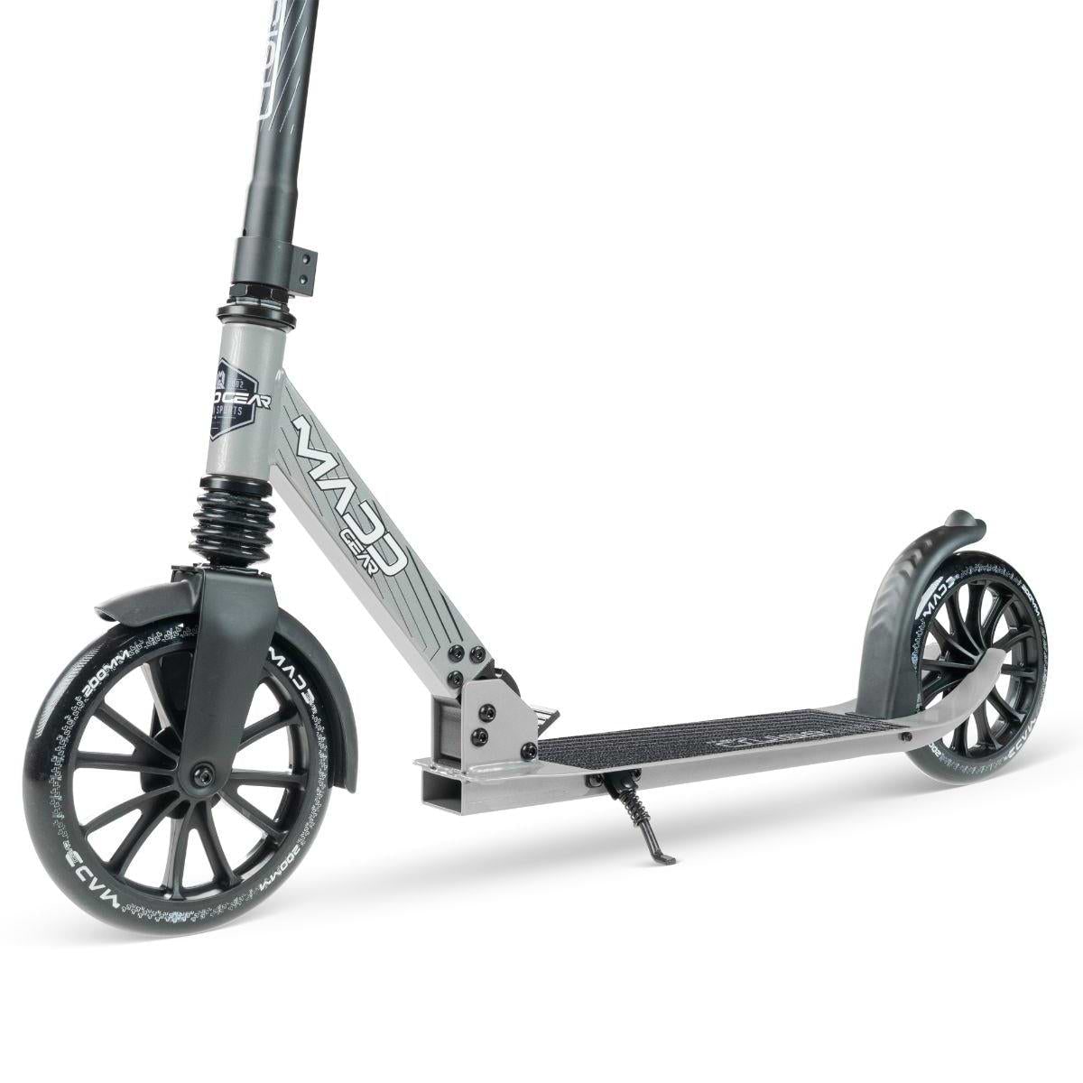 The Madd Gear Metro Cruise 250 Foldable Commuter Scooter in Black/Grey features large black wheels, front/rear fenders, a textured deck, and rear brake. Adjustable height makes it perfect for urban commuting or recreation.