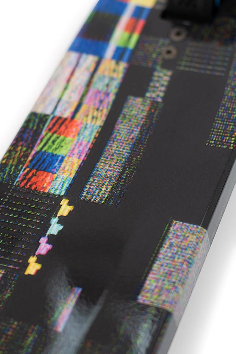 Close-up of a skateboard deck showcasing a modern design with multicolored geometric and pixelated patterns on a glossy black surface. The vibrant abstract visuals resemble the Nebula Wrap seen on the Slamm Mischief Complete Stunt Scooter - Glitch by Slamm, designed for high-end performance.