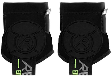 A pair of REKD Energy Covert Ankle Impact Skate Protection Guards in black with energy-absorbing padding and green-accented elastic straps, displayed side by side against a white background.