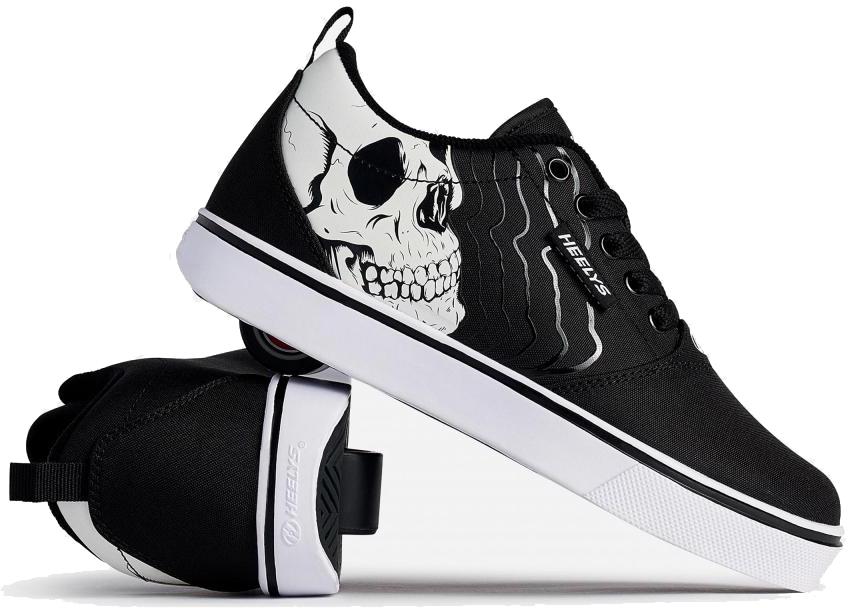 Heelys Pro 20 PRNT Glow Boys Shoes in black and white by Heelys feature low-profile wheels and a glow-in-the-dark skull graphic. One shoe stands upright, the other is angled to show the wheels in the heel.