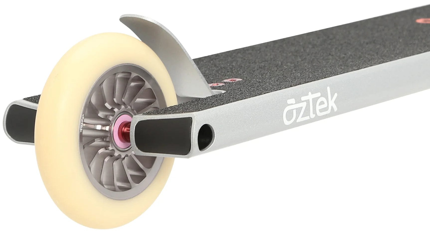Close-up of the rear section of a platinum silver Aztek Architect 2 Complete Stunt Scooter deck with black grip tape, showing a white wheel with a gray core and metal brake. The Aztek brand name is visible on the side of this street scooter.