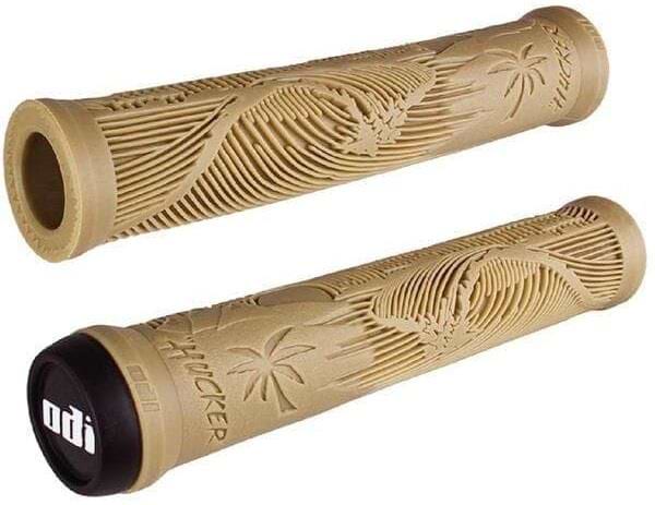 The ODI Hucker Flangeless Tan Stunt Scooter Grips (160mm) feature raised wave and palm tree designs, "Mucker" engraving, and black end caps with a white ODI logo. Ideal for bikes or stunt scooters.