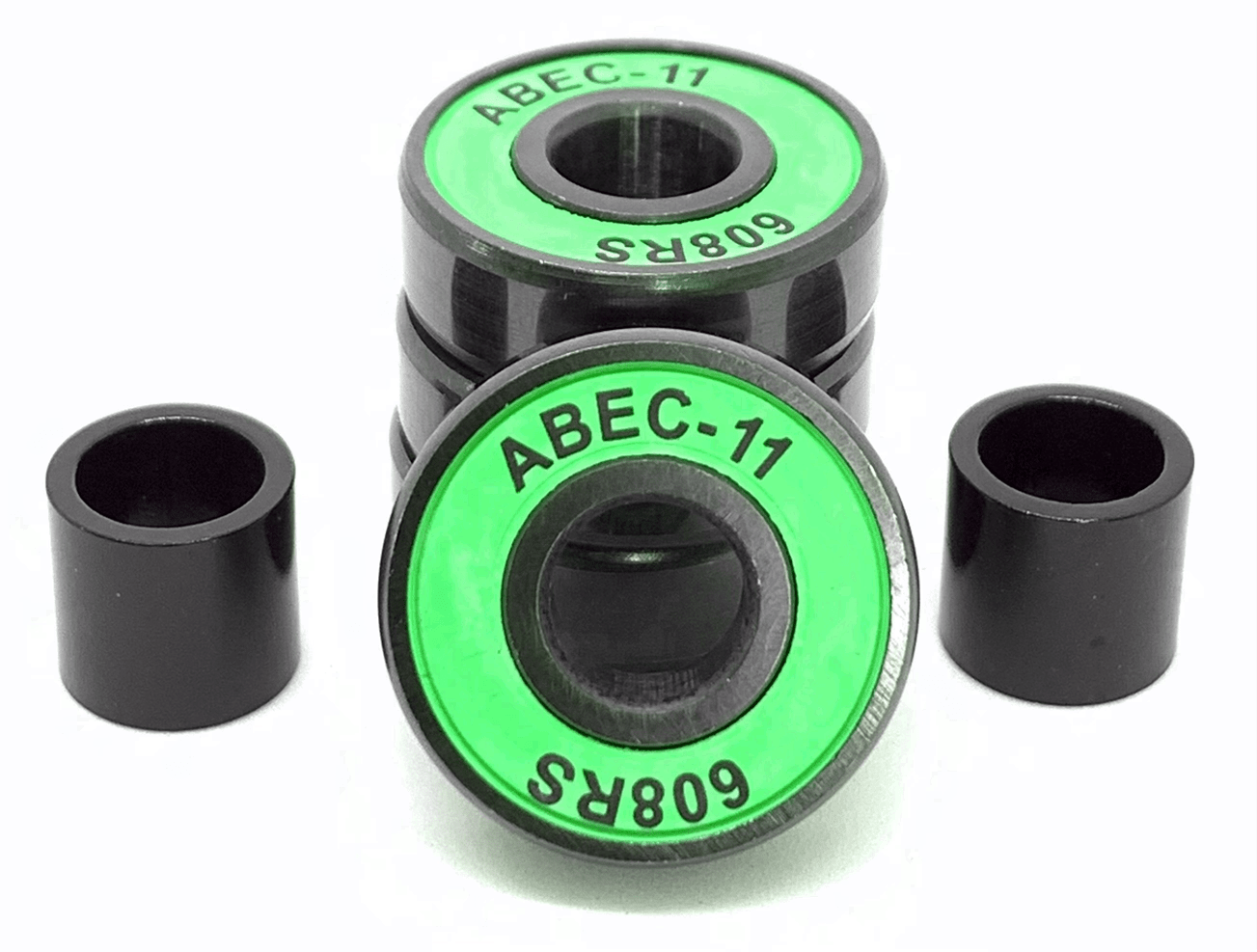 A set of Logic ABEC 11 green scooter bearings features high-quality components with a striking green and black design. Two bearings are stacked vertically while two more stand upright in front, poised for exceptional performance and speed. Accompanying them are two black cylindrical spacers that optimize a smooth riding experience.