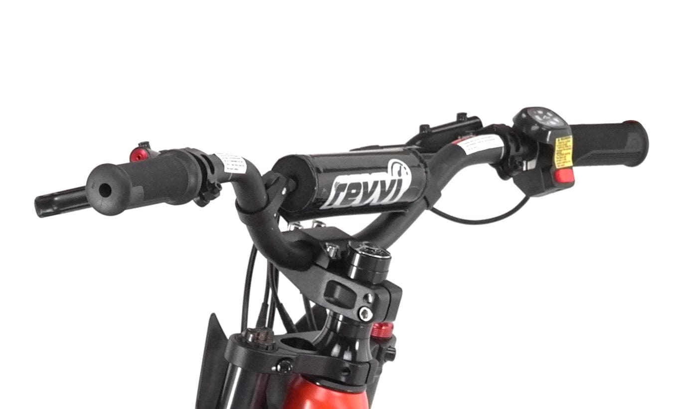 Close-up of a black bicycle handlebar with a digital display and grips, featuring control buttons and shifters. The "Revvi" logo is prominently displayed on the central bar of this Revvi 18" Kids Electric Balance Bike - Green. Its sleek design is enhanced by advanced features like hydraulic disc brakes. The background is white.