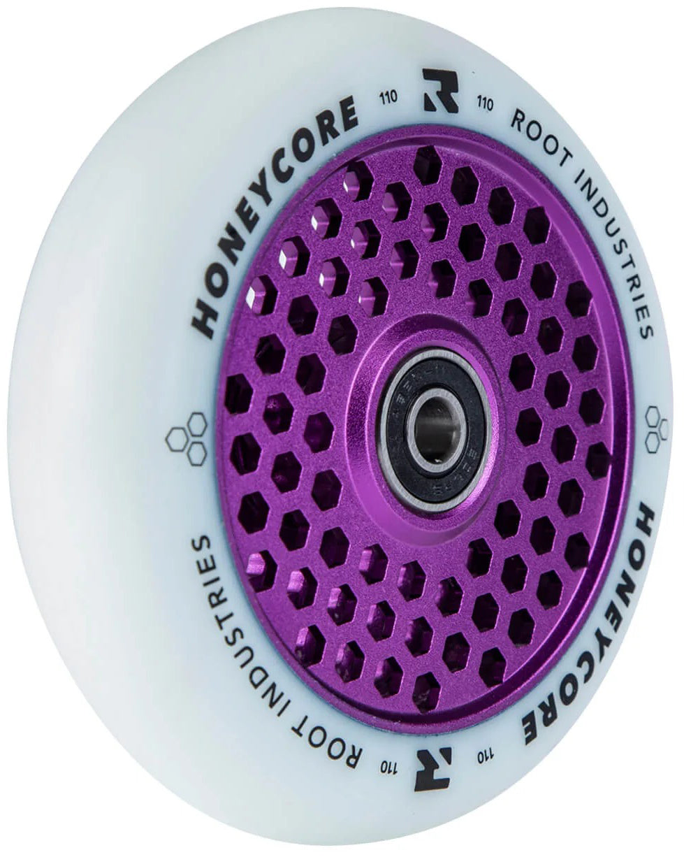 The Root Industries Honeycore 110mm Stunt Scooter Wheel in White/Purple features a striking purple honeycomb-patterned metal core and bold “HONEYCORE ROOT INDUSTRIES 110” black lettering around the rim. Designed by Root Industries, this wheel delivers both standout style and high performance for dedicated stunt scooter riders.