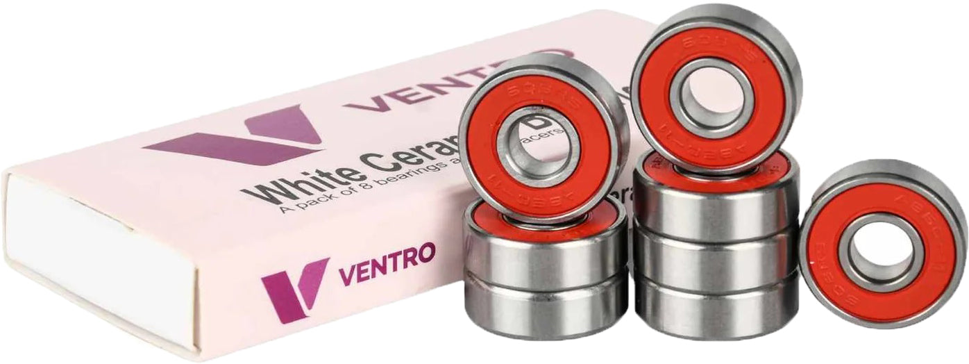 Eight metal ball bearings with red centers are stacked beside a pink and white Ventro box labeled "White Ceramic," indicating a set of high-performance Ventro Ceramic ABEC 11 Red Bearings (set of 8), designed for skateboard use in the standard 608 size.