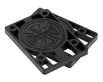 A pair of Independent Skateboard Riser Pads (1/8") in black, complete with the iconic Indy trucks logo embossed on them. These custom-molded risers feature a circular design in the center and multiple holes for easy mounting.