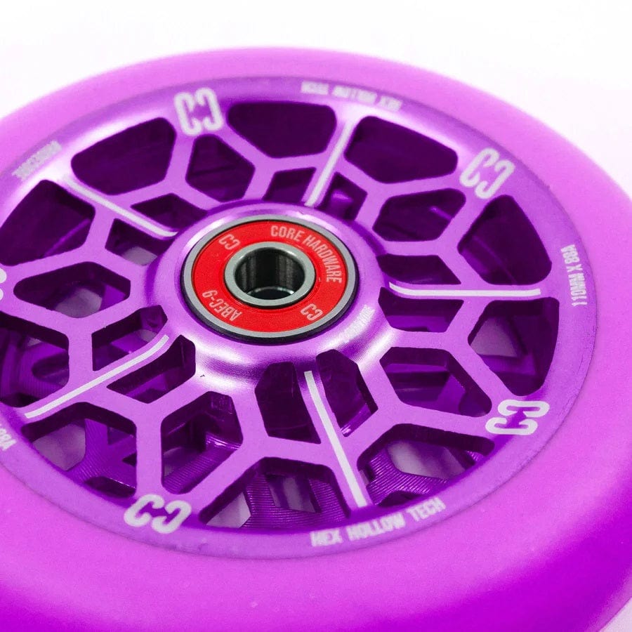 A close-up of the purple CORE Hex Hollow Core 110mm Stunt Scooter Wheel reveals its geometric spoke design. The red core prominently displays "Core Hardware" and "C3." For enhanced performance, the outer rim is equipped with a stellar 88a compound and ABEC 9 Bearings.
