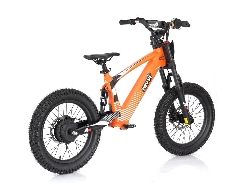 The Revvi 18" Kids Electric Balance Bike in orange offers thick black tires, front suspension, and a sleek frame. This motorized bike has a compact, sporty design perfect for young riders, with branding on the frame and handlebars adding an extra touch of style.
