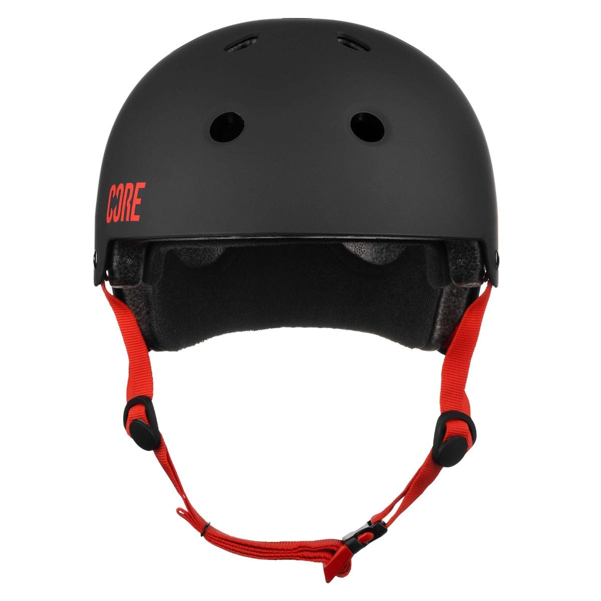 The CORE Street Skate / Scooter Helmet, available in black with red accents, showcases a sleek matte finish. It features bold red straps and the iconic "CORE" logo prominently displayed on the side. Designed for comfort and safety, it comes equipped with CORE Lux Pads and multiple ventilation holes, making it ideal for activities such as cycling or skateboarding.
