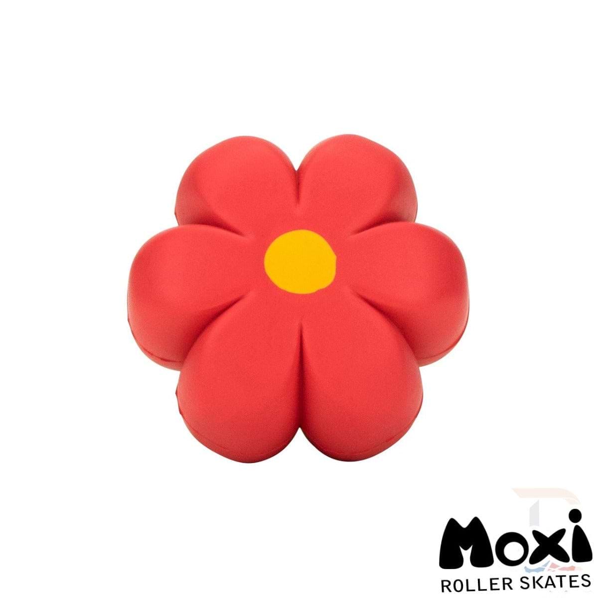 A vibrant red hibiscus with a soft texture and six petals, complete with a yellow center, serves as an ideal toy or accessory. It is adorned with the Moxi logo in black text on the bottom right corner, evoking the colorful design of their Moxi Brake Petal Roller Skate Toe Stops in Red Hibiscus.