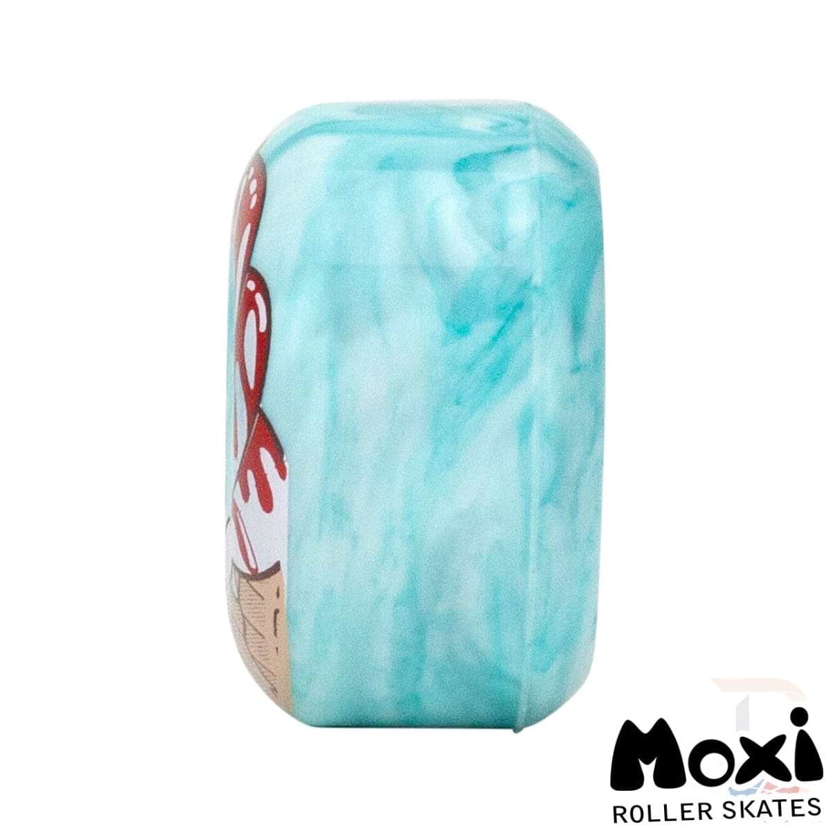 A side view showcases a Creme De Menthe Teal Moxi Fundae 92A Quad Roller Skate Wheel with a smooth, marbled design. Partial artwork in red and beige adorns the side, while the Moxi logo is positioned in the bottom right corner, highlighting their hybrid street and skatepark versatility.