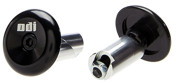 Close-up image of two ODI Aluminium Stunt Scooter Bar Ends in black. One is upright, showcasing the branded head with an Allen key bolt, while the other is tilted to reveal the durable fastening mechanism. Ideal for upgrading your handlebars with premium ODI scooter accessories.