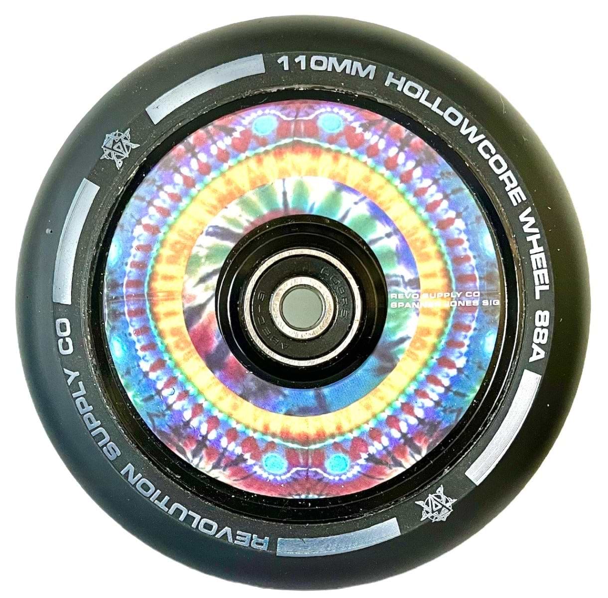 Introducing the Revolution Hollowcore 110mm Stunt Scooter Wheel - Spanner Jones Signature, featuring a vibrant kaleidoscope pattern with an 88A hardness rating. The outer edge proudly displays the Revolution branding. This colorful wheel showcases a symmetrical mandala design complemented by a black outer rim, making it perfect for enhancing your ride.