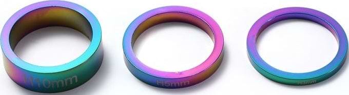 A row of Blunt Envy Scooter Headset Spacers in Oil Slick Neochrome, featuring a metallic finish that smoothly transitions between shades of blue, purple, and green. These spacers come in varying widths of 10mm, 5mm, and 3mm, perfect for customizing your stunt scooter.