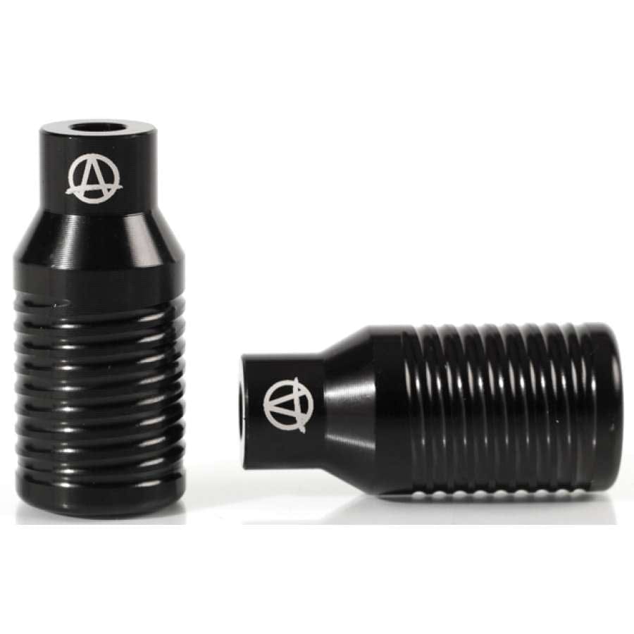 Two Apex Bowie Aluminium Stunt Scooter Pegs in black are displayed, featuring a cylindrical and ribbed design. One peg is placed upright while the other is laid on its side. Both showcase the Apex logo, a stylized "A" within a circle, indicative of their high-quality craftsmanship.