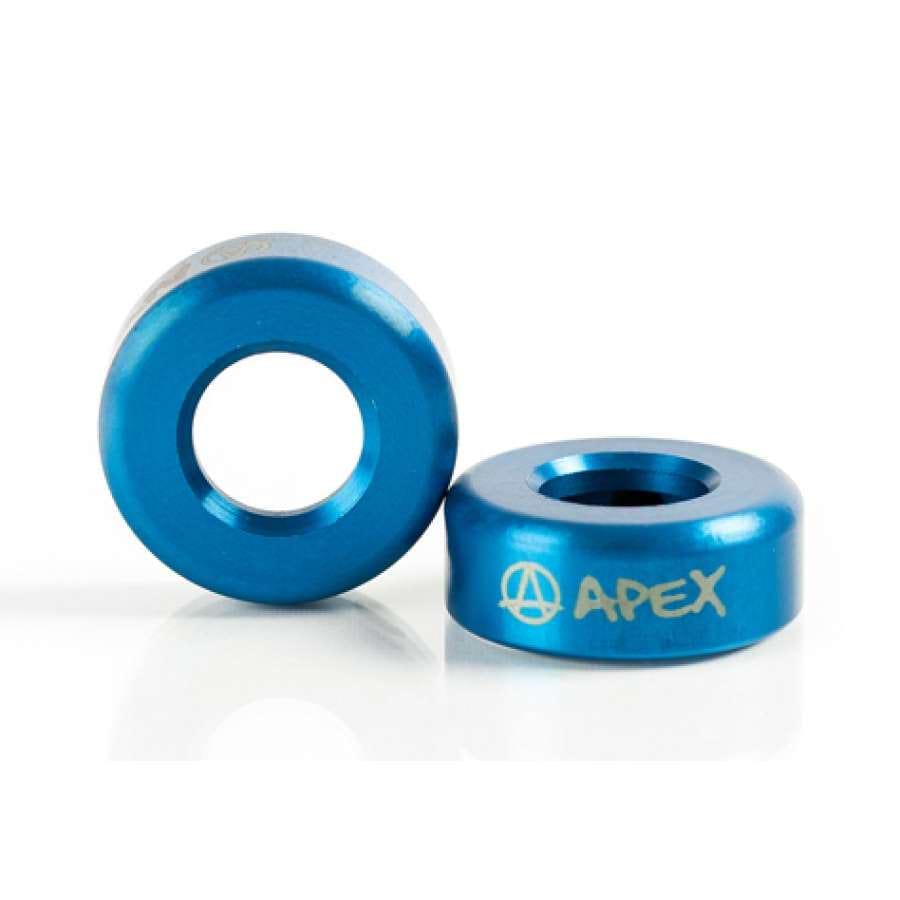 Two blue, cylindrical metal washers are featured. One is positioned upright, showcasing its hollow center, while the other is placed flat with "APEX" elegantly etched in silver. Designed as bar ends for the Apex Aluminium Scooter, they capture and reflect light, emphasizing their shiny and durable finish.