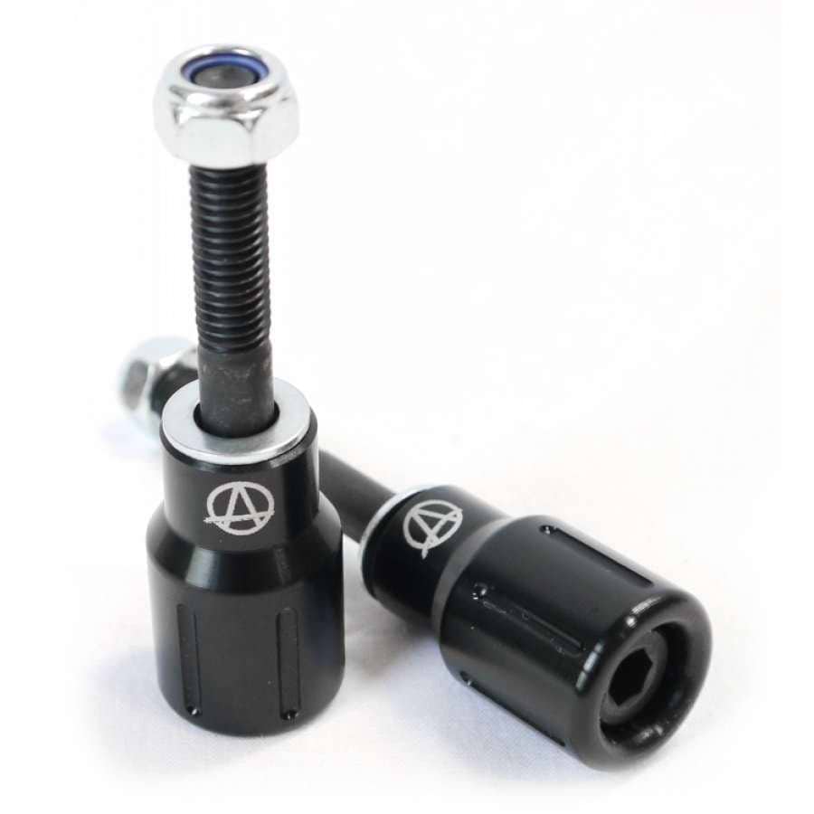 Two black frame sliders with silver accents rest on a white surface. Each features a visible bolt, and proudly displays a distinctive logo on their sides, reminiscent of the precision seen in Apex Barnaynay Aluminium Stunt Scooter Pegs - Black.