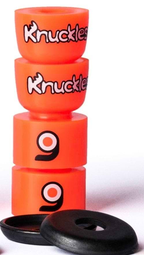 Orangatang Knuckles Orange Longboard Bushings feature a vibrant orange design with black logos, showcasing their high-rebound formula, alongside two black response pads in the foreground.