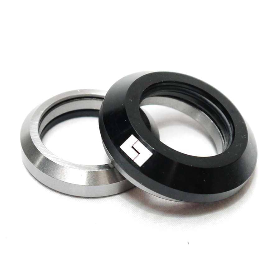 Two metallic camera lens adapters, one in silver and one in black, are placed overlapping on a white surface. The black adapter, reminiscent of the sleek design of the Logic Integrated Stunt Scooter Headset - Black by Logic, features a small white logo.