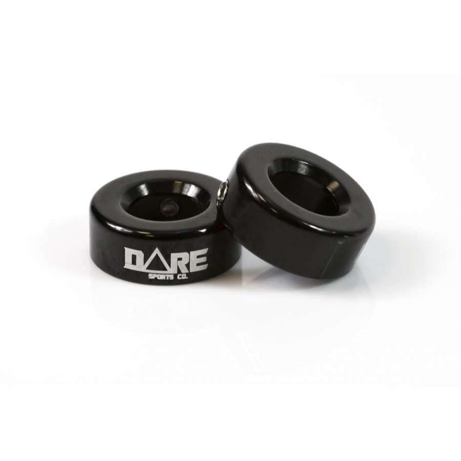 A pair of black, round spacer rings designed for CNC aluminium stunt scooters feature the "DARE" logo on one ring. These long-lasting and durable components are displayed against a simple white background.