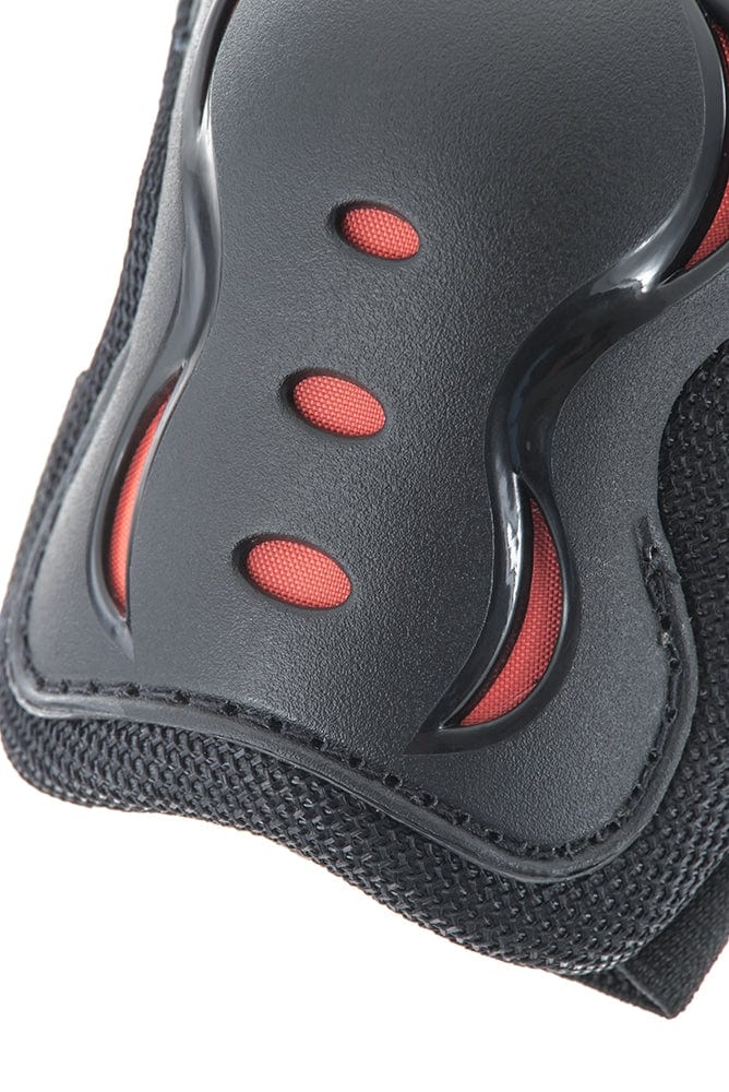 Close-up of a black and red protective gear, possibly a knee or elbow pad from the SFR Essentials Junior Triple Skate Protection Pad Set - Black, featuring three ventilation holes and a textured surface, offering entry-level protection with integrated impact caps.
