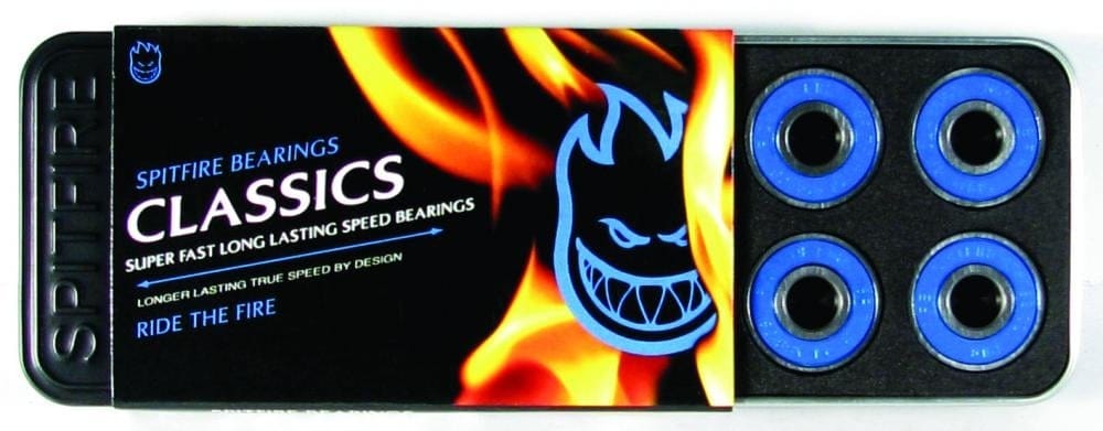 A partially opened package of Spitfire Classic Blue Skateboard Bearings reveals four blue bearings inside. The packaging displays a flame graphic and logo, prominently featuring the words "Classics" along with the phrases "Precision Speed Bearings" and "Ride the Fire.