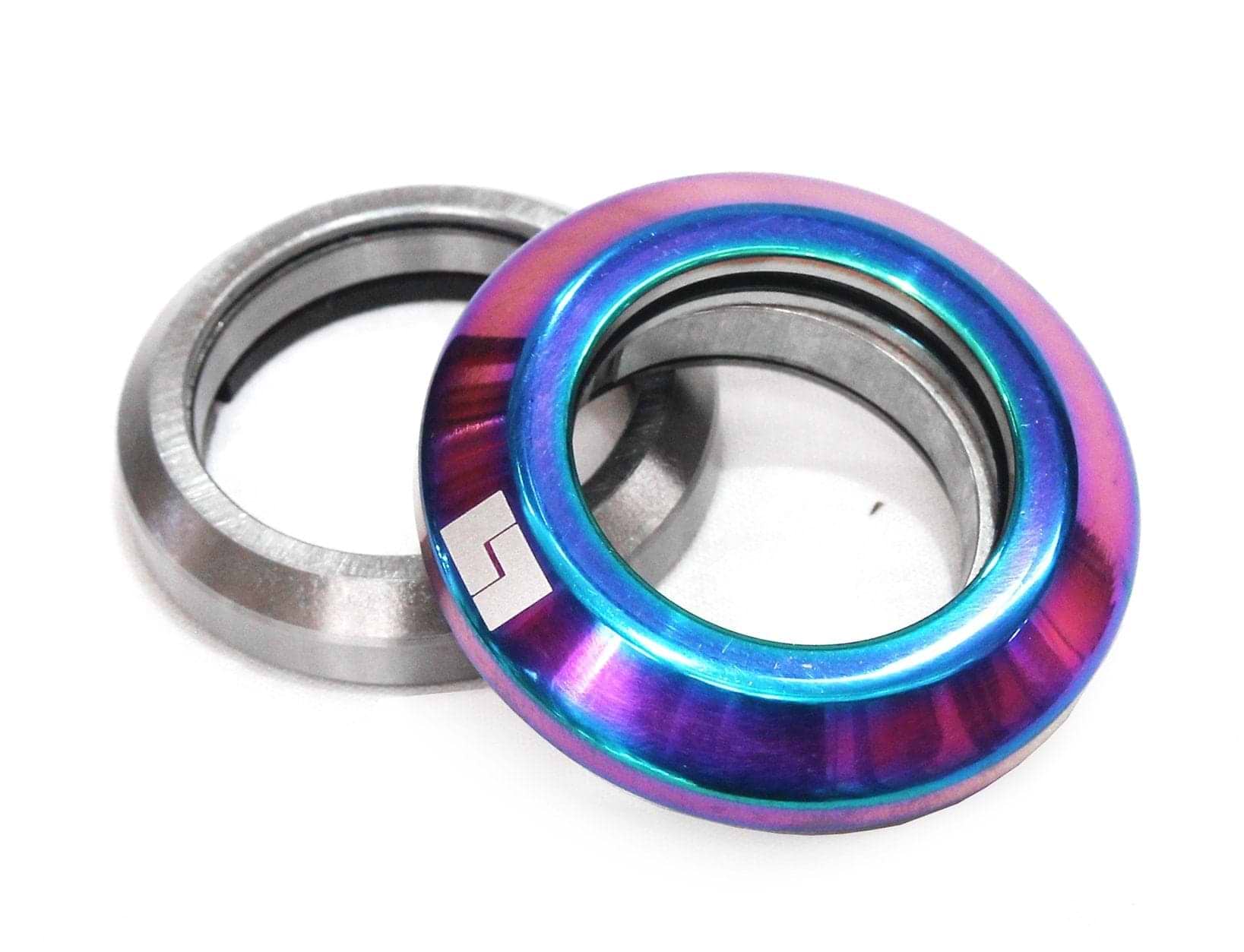 Two metal headset cups, one featuring a silver finish and the other adorned with a vibrant neochrome coating, are displayed together. The neochrome cup proudly displays the Logic Integrated Stunt Scooter Headset logo, ensuring seamless integration with scooter forks using precision-sealed bearings.