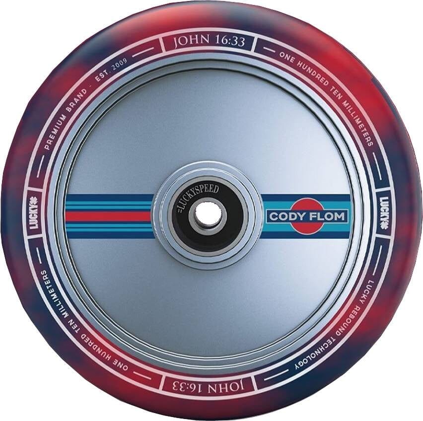 A detailed view of the Lucky Lunar 110mm Stunt Scooter Wheel - Cody Flom Signature V3 highlights its vibrant red and blue design. The center features the "Cody Flom" logo surrounded by "JOHN 16:33," "LUCKY," and "PREMIUM BRAND," all enhanced by Lucky Rebound Technology for improved riding performance.