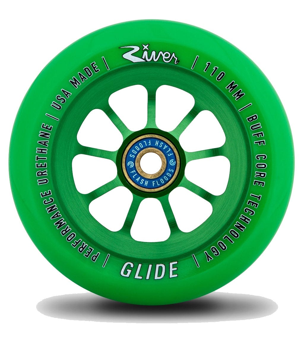 The Emerald Green River Glide 110mm Stunt Scooter Wheel boasts a spoked, anodised 6061-T6 aluminium core engraved with "Performance Urethane," "USA Made," "110 mm," and "Buff Core Technology." The blue central hub adds further branding, blending sleek design with premium craftsmanship.