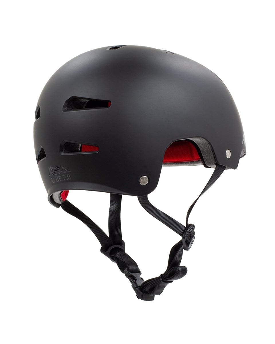 Introducing the REKD Elite 2.0 Skate/Scooter Helmet, a black matte helmet designed for action sports enthusiasts. This certified helmet features ventilation slits and plush red interior padding, along with adjustable black straps. The sleek design combines top-notch protection with stylish flair, making it perfect for outdoor adventurers.