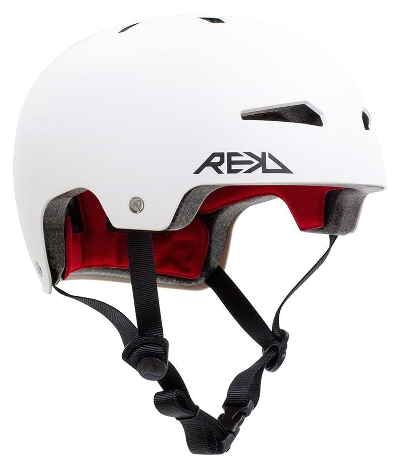 The REKD Elite 2.0 Skate/Scooter Helmet is a white action sports helmet from REKD, featuring black straps and a vibrant red interior. It is designed with ventilation holes and prominently showcases the "REKD" logo on its side.