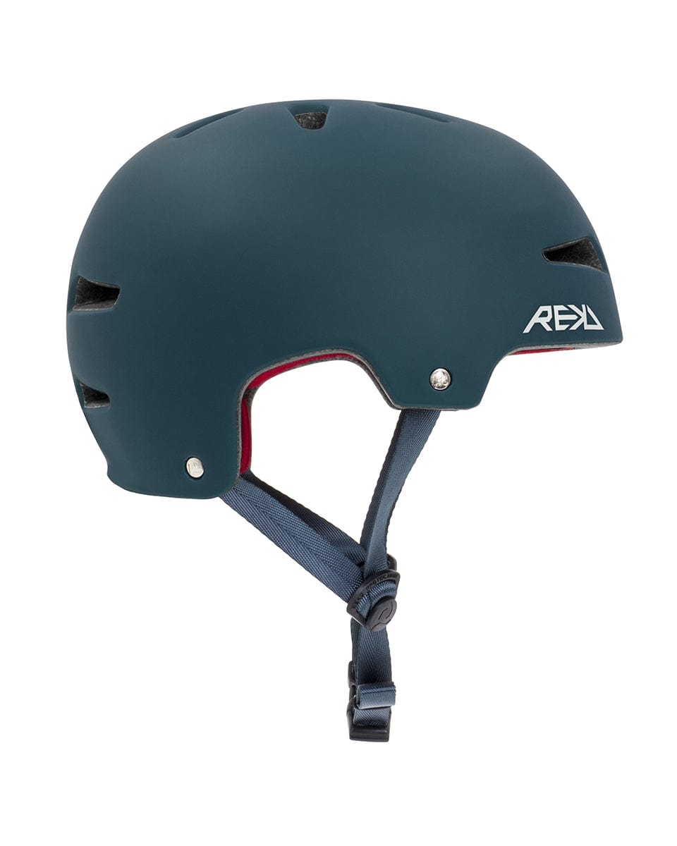 A blue REKD Ultralite In-Mold Skate/Scooter Helmet, featuring angular ventilation slots and a vibrant red interior lining. Ideal for action sports, it includes an adjustable black chin strap with a buckle for secure fastening. The helmet's sleek design prominently displays the REKD logo in white text on the side.