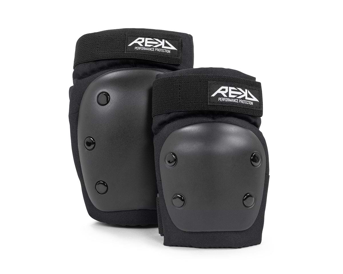 The REKD Youth Heavy Duty Double Skate Protection Pad Set in black features a robust design with hard shell caps and adjustable velcro straps adorned with the REKD logo. These pads are essential for ensuring safety during activities such as skating or construction work.