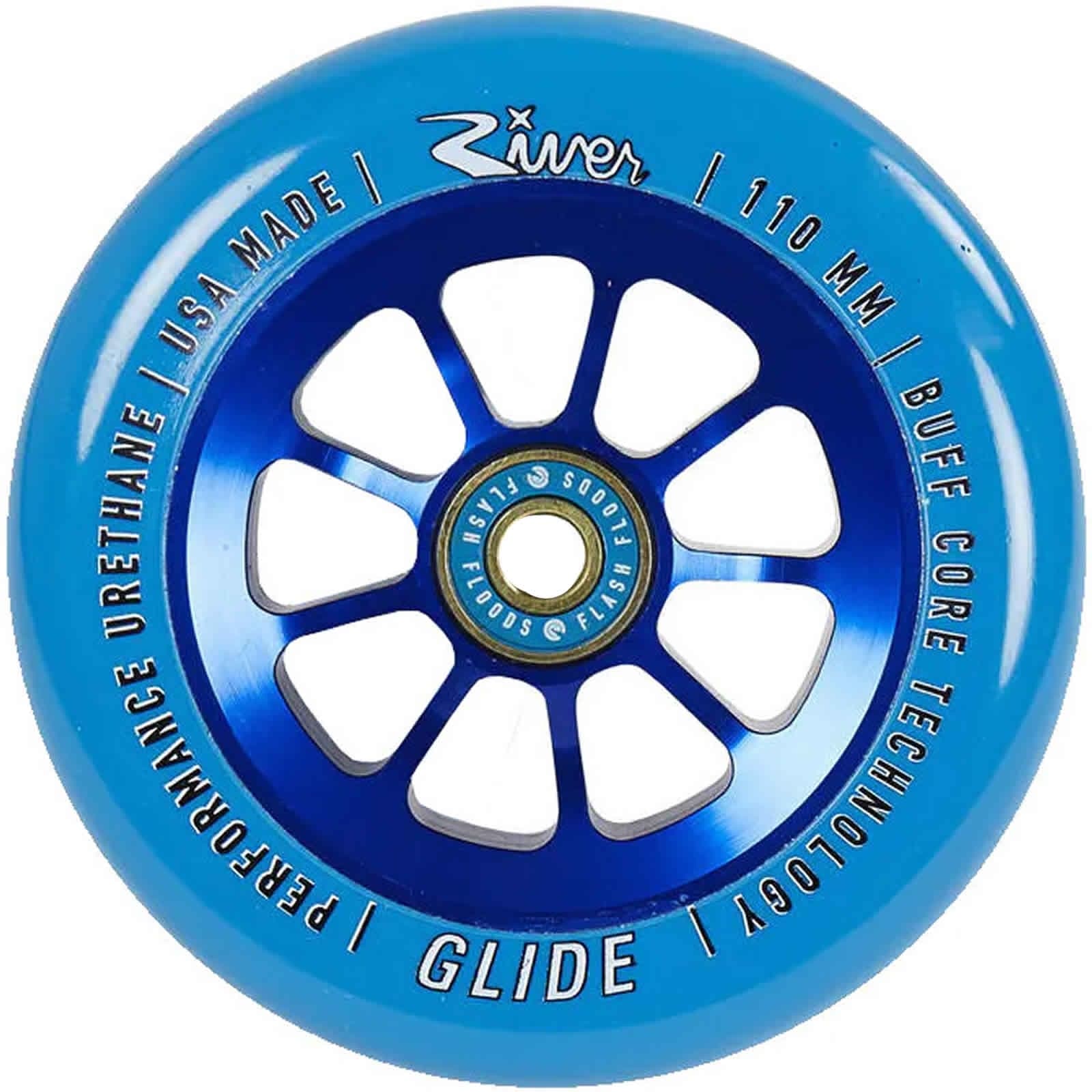 The River Glide 110mm Stunt Scooter Wheel in Sapphire Blue showcases white text around the edge with phrases like "River Glide Scooter Wheels," "Performance Urethane," and "Buff Core Technology." Its core is crafted from anodized 6061-T6 aluminum in metallic blue, featuring eight spokes. The wheel includes River Flash Flood bearings, is made in the USA, and measures 110 mm.