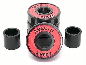 Close-up of four Logic ABEC 11 Red Scooter Bearings stacked on a white surface, ideal for performance speed enthusiasts. Two additional black cylindrical spacers are positioned on each side of the stacked bearings.