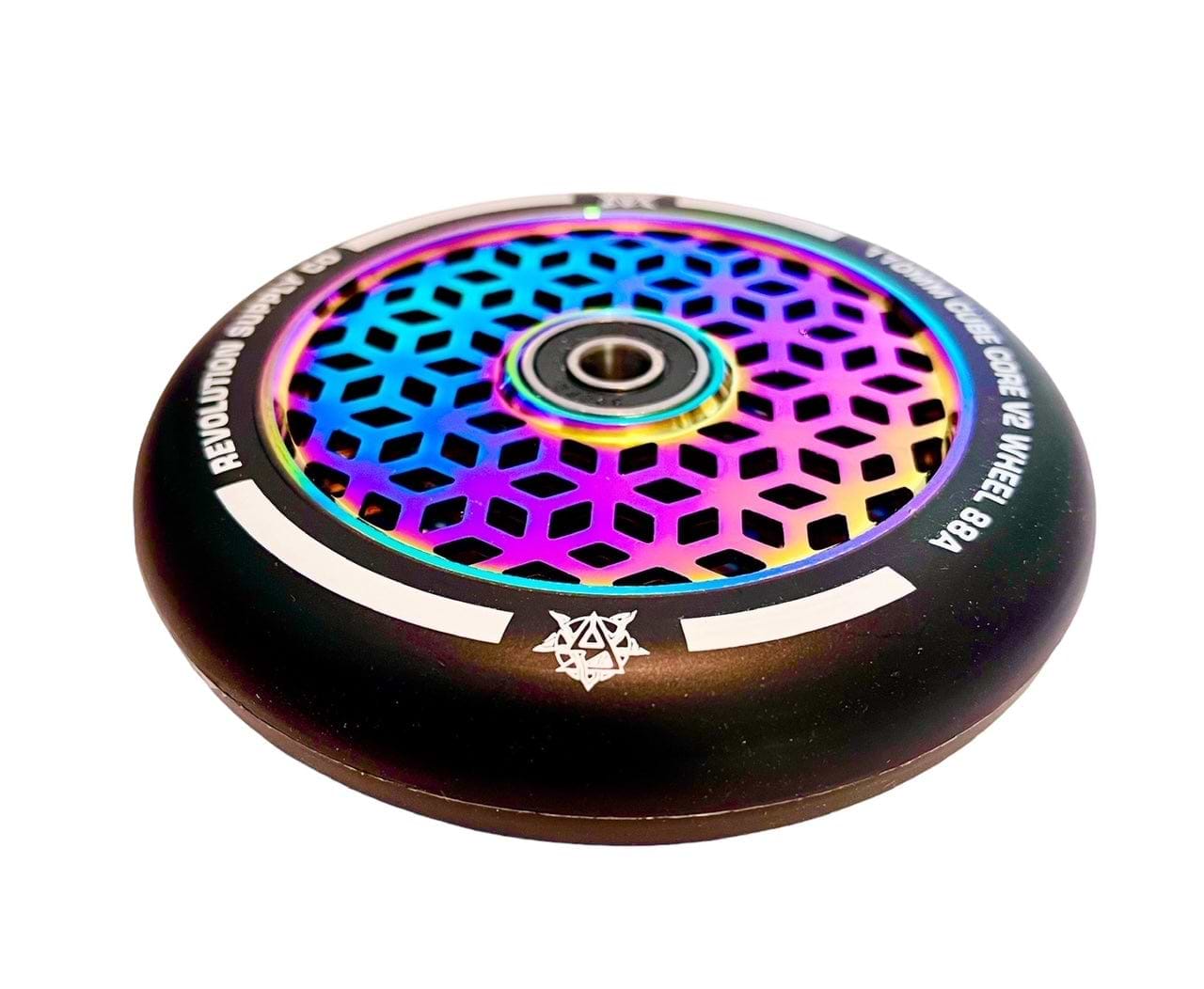 Revolution's Cubed Core Ultralite 110mm Stunt Scooter Wheel in Neochrome Rainbow features a vibrant hexagonal lattice pattern. The design includes a black outer rim with white text, complemented by the visible central axle for a sleek appearance, and is adorned with a small star emblem for added flair.