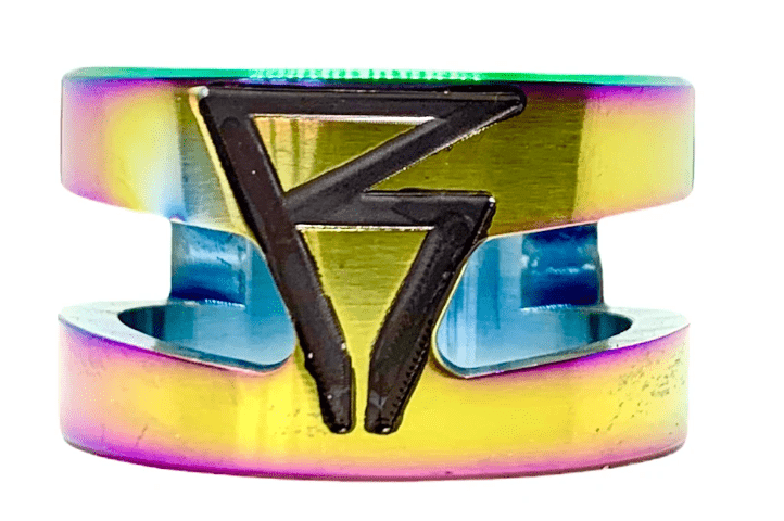 A vibrant neochrome clamp from Revolution, showcasing a striking black angular design. Made from robust 6061-T6 aluminum, this Revolution Super Lite 2 Bolt Oversized Stunt Scooter Clamp features a cut-out section and displays an iridescent finish with hues of yellow, green, and purple.