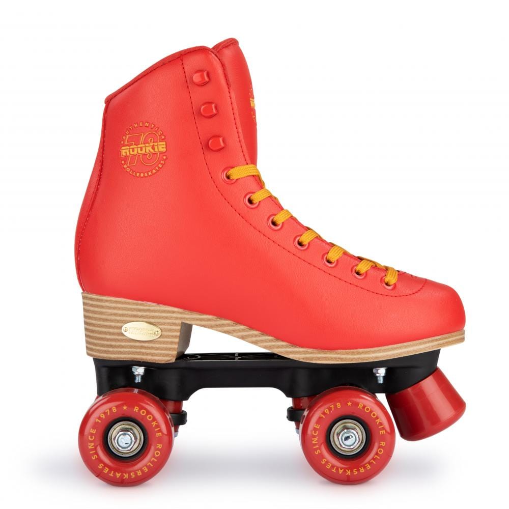 The Rookie Classic 78 Quad Roller Skates - Red by Rookie are lively red skates that come with yellow laces and a wooden heel. They feature four red wheels on a black base, and their vegan-friendly design includes a round logo at the ankle along with stylish metal accents on the sides.