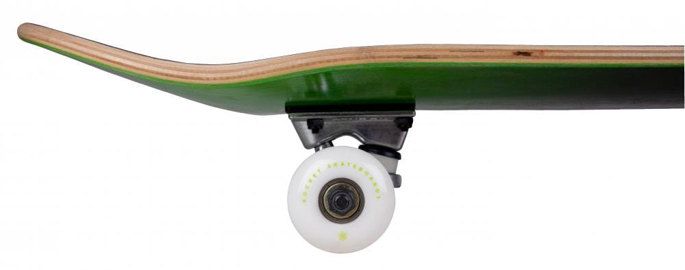 A side view of the Rocket Double Dipped Black / Green Complete Skateboard showcases its green 7-ply hardrock maple wooden deck with a natural wood edge. Equipped with white wheels and black and silver trucks, this skateboard is ideal for beginner skaters. The wheel is adorned with small circular graphics near its center.