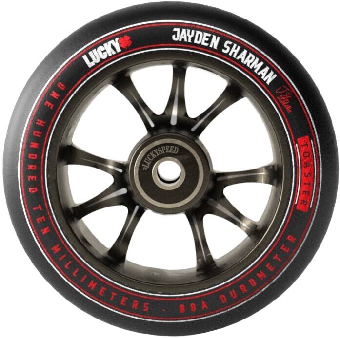 A close-up of a Lucky Toaster 110mm Stunt Scooter Wheel - Jayden Sharman Signature V2 in black highlights its silver spokes and the bold red and white branding. The phrases "High Rebound Urethane" and "Jayden Sharman" are prominently displayed, with "110 millimeters 88A durometer" specifications visible on the outer rim.