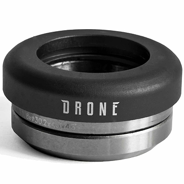 A close-up image of a metallic headset component, part of the Drone Synergy 2 Integrated Stunt Scooter Headset by Drone, displays "DRONE" engraved on it. It features smooth bearings and a 6061 aluminium top cap with a sleek, rounded black top and polished silver bottom, ideal for an integrated stunt scooter setup.