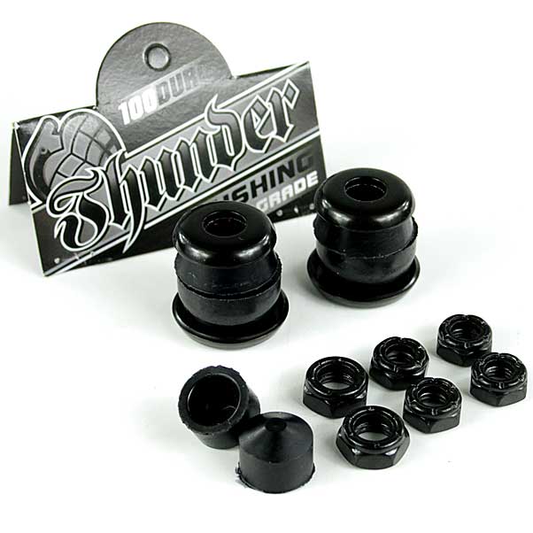 A set of Thunder Trucks Black Bushing Rebuild Kit - 100A showcasing high rebound urethane bushings. The image displays two sets of black bushings and eight black nuts on a white background, with Thunder's branded packaging featured in the background.
