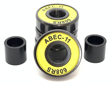 Close-up of a pack of four Logic ABEC 11 Yellow Scooter Bearings, featuring a striking black and yellow design, labeled "608RS" for optimal speed performance. These premium bearings are accompanied by two sleek black cylindrical spacers, all set against a clean white background.