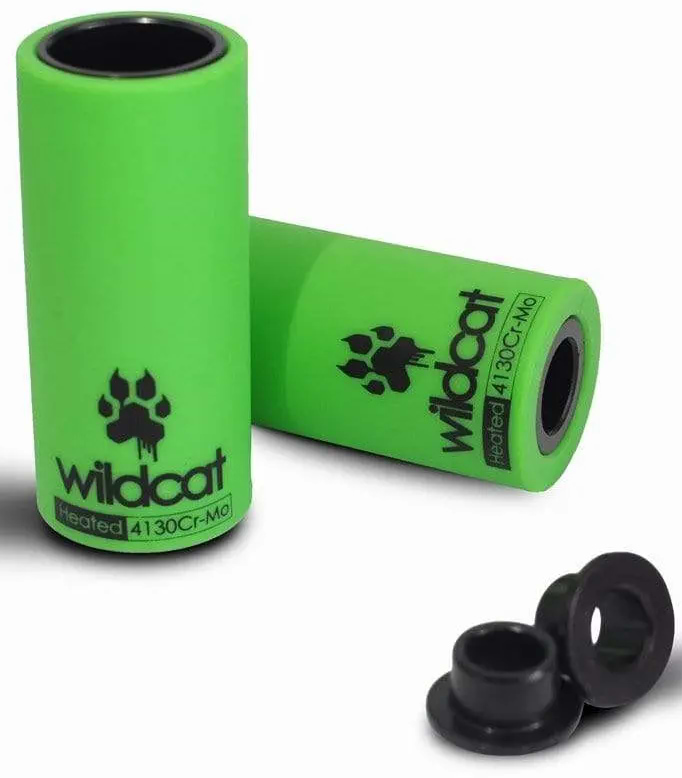 Two bright green Wildcat Pro Mini BMX Pegs by Wildcat, featuring black paw print logos and resembling chromoly BMX pegs, are shown standing upright and lying down next to two small black rings.