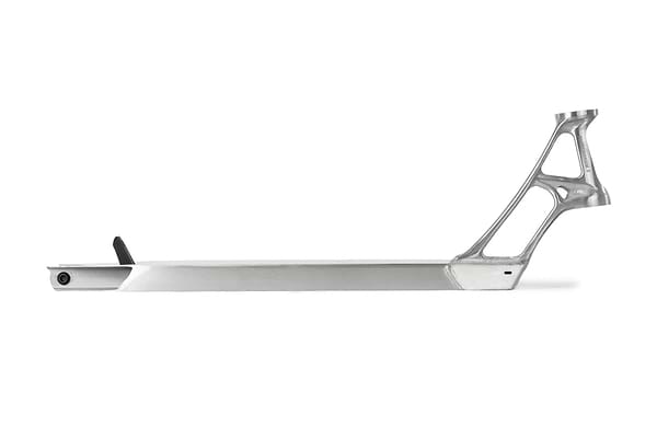 The Ethic DTC Pandemonium V2 Raw Stunt Scooter Deck, measuring 5.1" x 18.1", boasts a sleek and minimalist design with an integrated neck and head tube. Crafted from durable 6061-T6 aluminum, this deck is lightweight with a modern aesthetic, finished in brushed metal and accented by a small black component at one end.