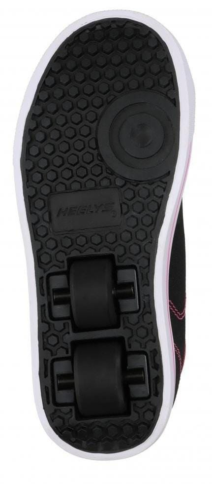 The image shows the sole of Heelys Classic X2 Girls Shoes in black, white, and hot pink, featuring two low-profile wheels in the heel, a hexagonal tread pattern with a white edge, and visible "HEELYS" branding.